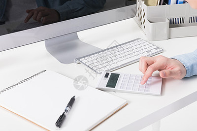 會(huì)計(jì)在桌上用計(jì)算機(jī)算賬